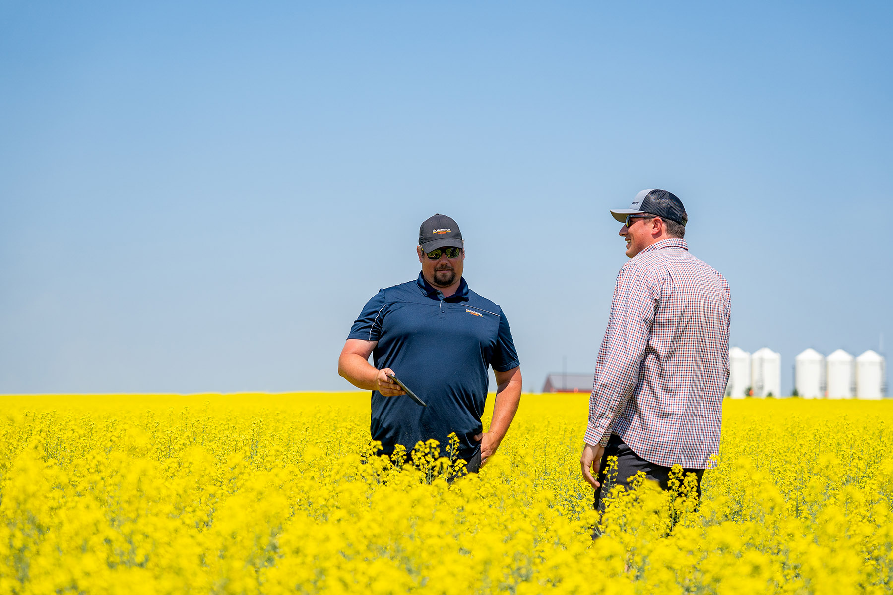 Agronomist and Grower in Field with Richardson Pioneer Elevator in Background